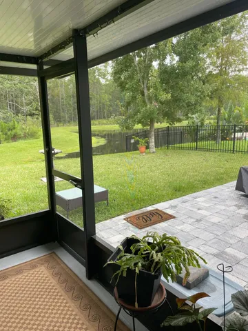 a view of a patio with table and chairs under an umbrella