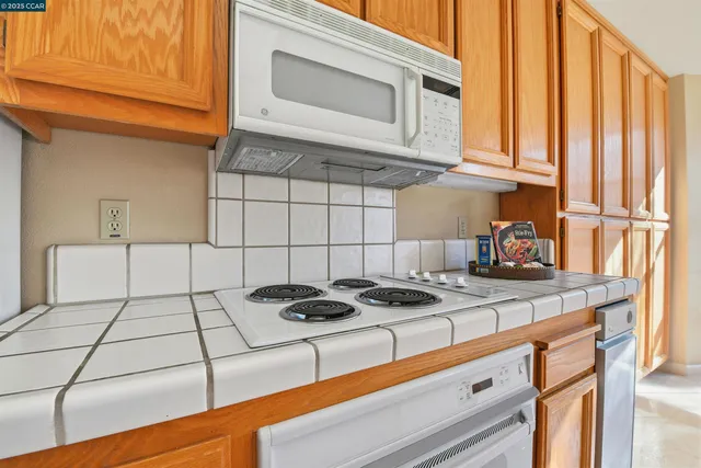 a kitchen with granite countertop cabinets and a stove top oven