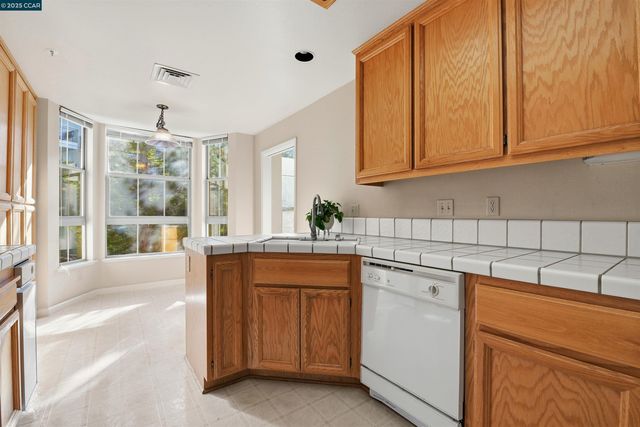 a kitchen with stainless steel appliances granite countertop a sink and cabinets with wooden floor