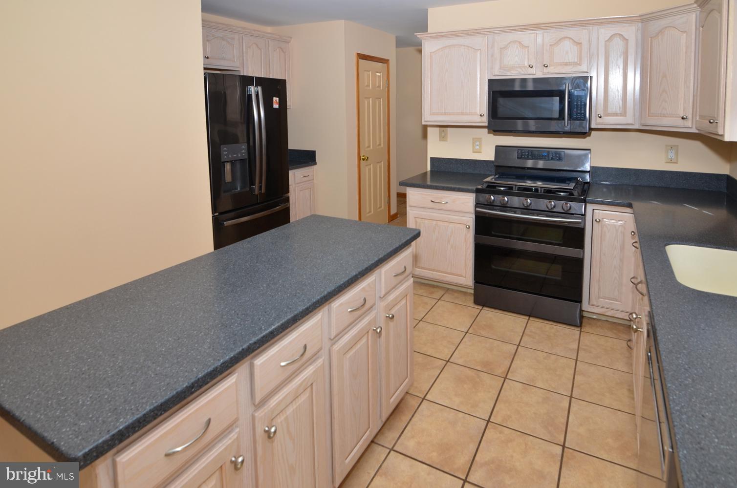 9 Noa Court Hamilton, NJ 08690 - Photo 15 of 47 a kitchen with granite countertop a stove and a refrigerator