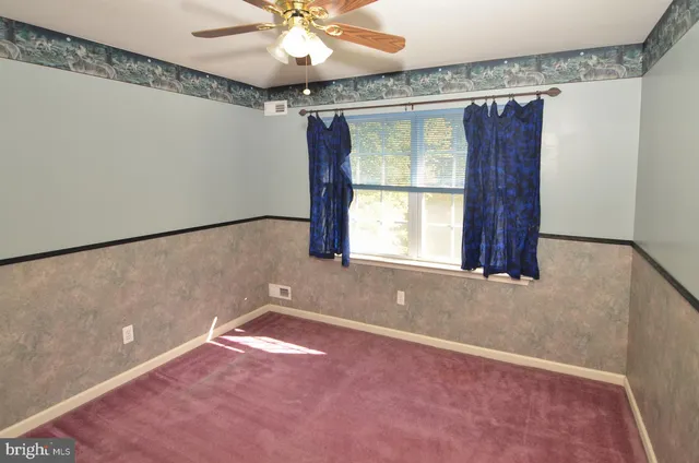 a view of a livingroom with a fan and a window