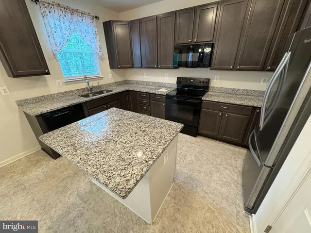 a kitchen with a sink a stove and cabinets