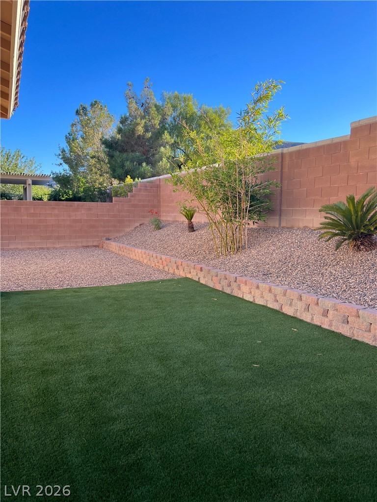 5981 Honeysuckle Ridge Street Las Vegas, NV 89148 - Photo 28 of 29 Green turf and low-maintenance landscaping offer a serene backyard escape.
