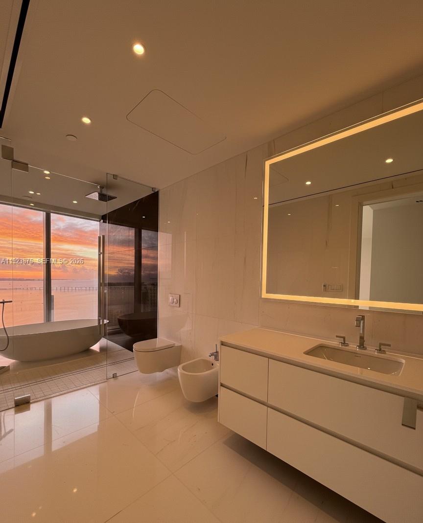 300 Biscayne Blvd Way, Unit 4201 Miami, FL 33131 - Photo 14 of 21 a spacious bathroom with a double vanity sink a mirror and a bathtub