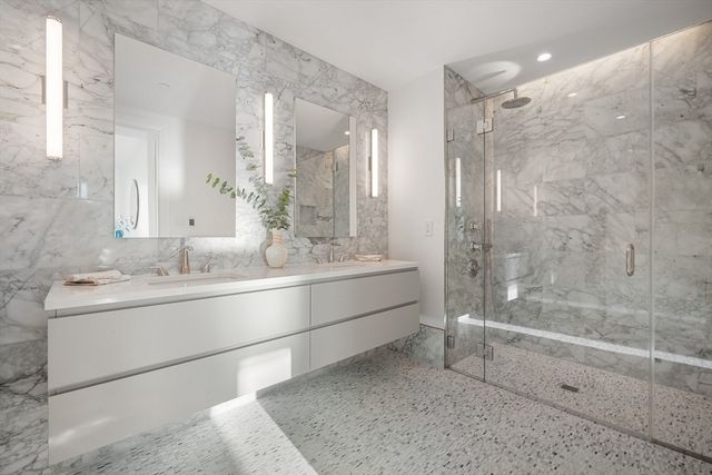 a bathroom with a granite countertop sink mirror and a bath tub