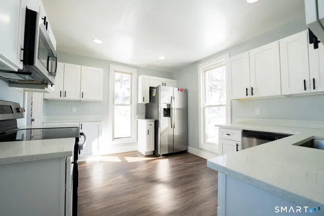 a kitchen with stainless steel appliances granite countertop a refrigerator and a stove top oven