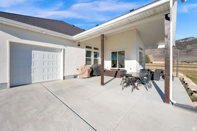 352 East Boulderville Road Oakley, UT 84055 - Photo 44 of 62 View of patio / terrace with outdoor dining space, an attached garage, a grill, and concrete driveway