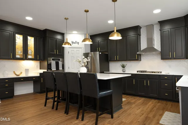 a kitchen with granite countertop a stove a sink a dining table and chairs