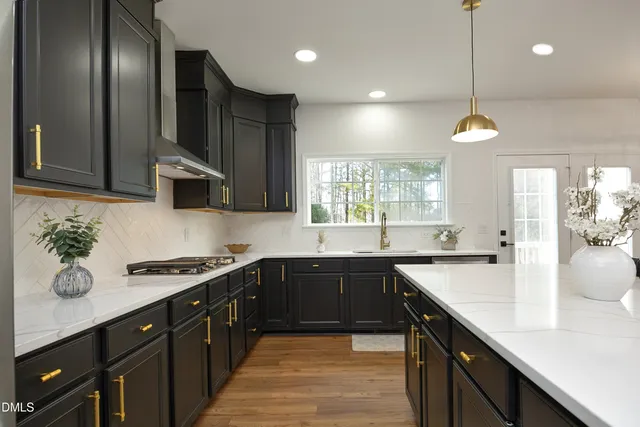 a kitchen with stainless steel appliances a sink stove and cabinets