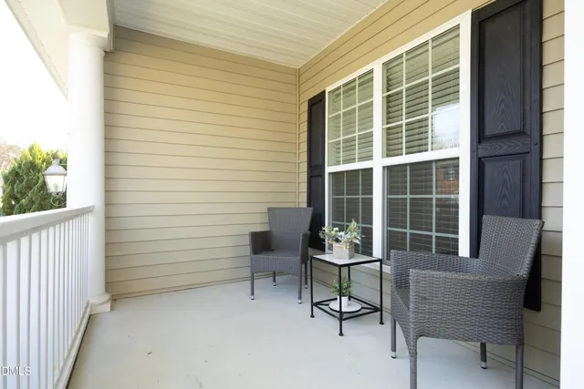a view of a house with a chair and a potted plant next to a window