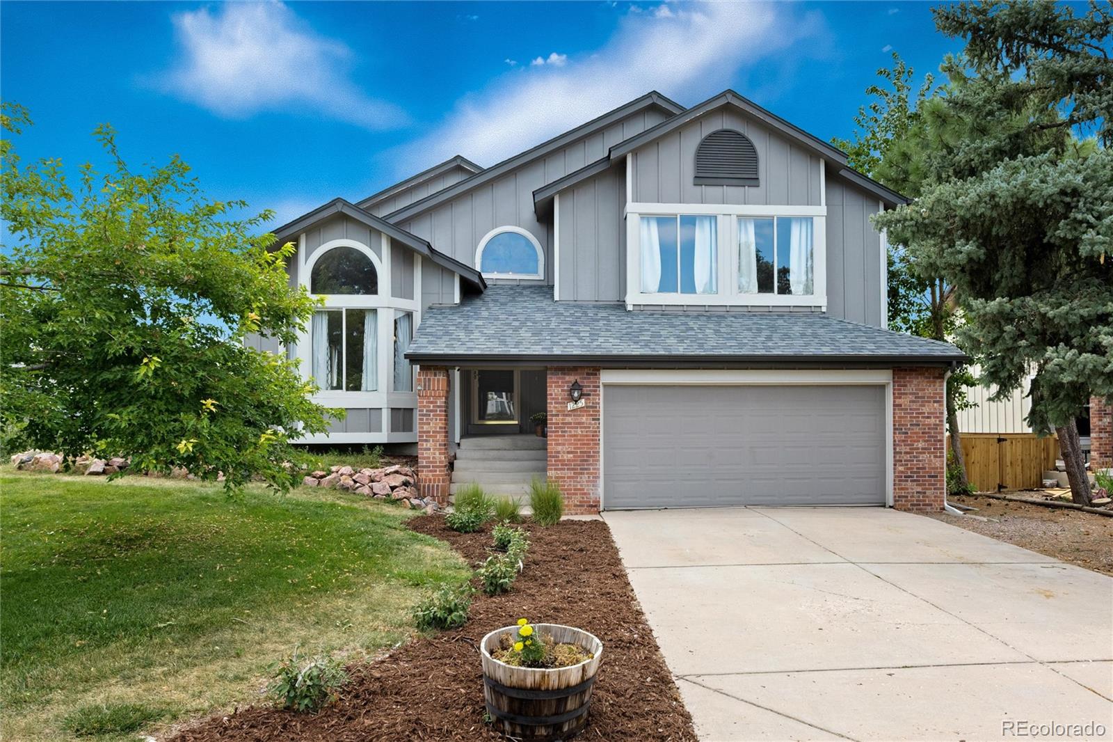 1225 East Goldsmith Drive Highlands Ranch, CO 80126 - Photo 1 of 40 a front view of a house with garden