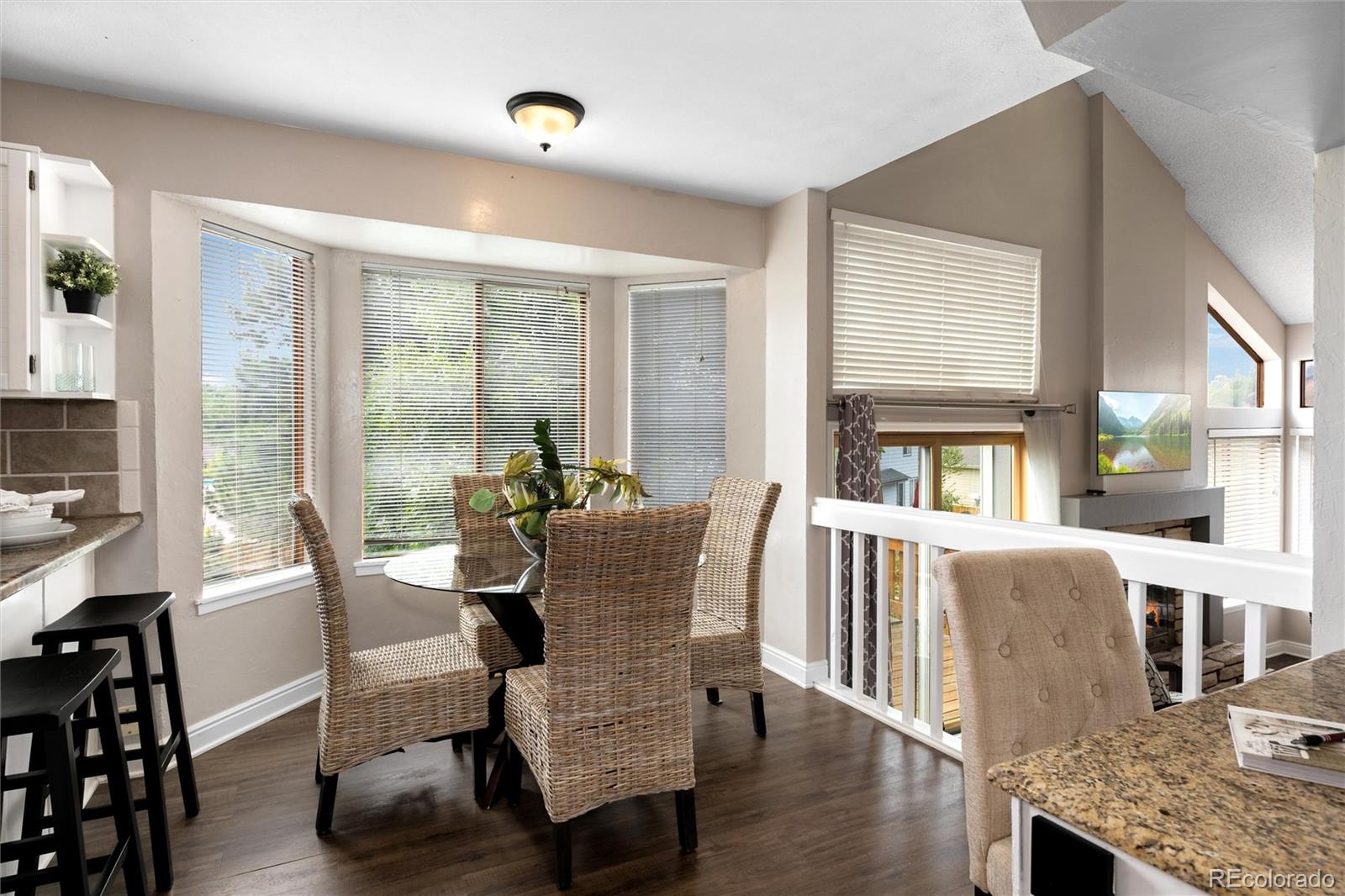 1225 East Goldsmith Drive Highlands Ranch, CO 80126 - Photo 11 of 40 a dining room with furniture large windows and wooden floor