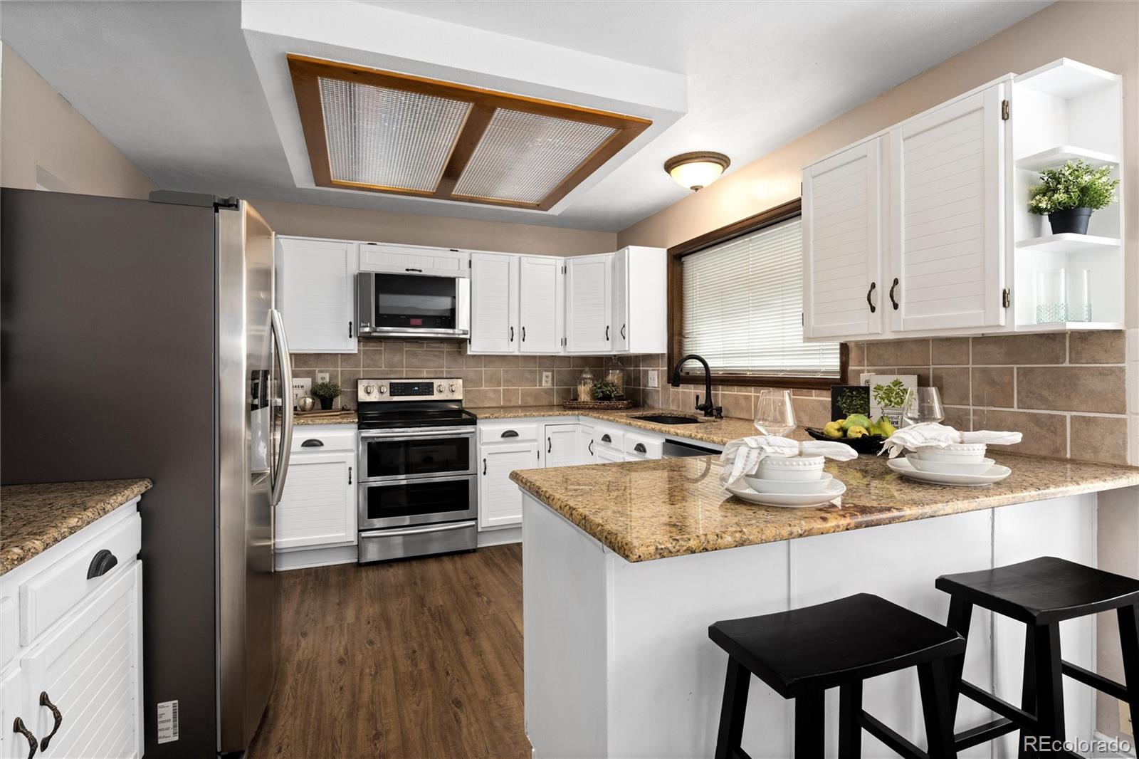 1225 East Goldsmith Drive Highlands Ranch, CO 80126 - Photo 13 of 40 a kitchen with a stove a sink and a refrigerator
