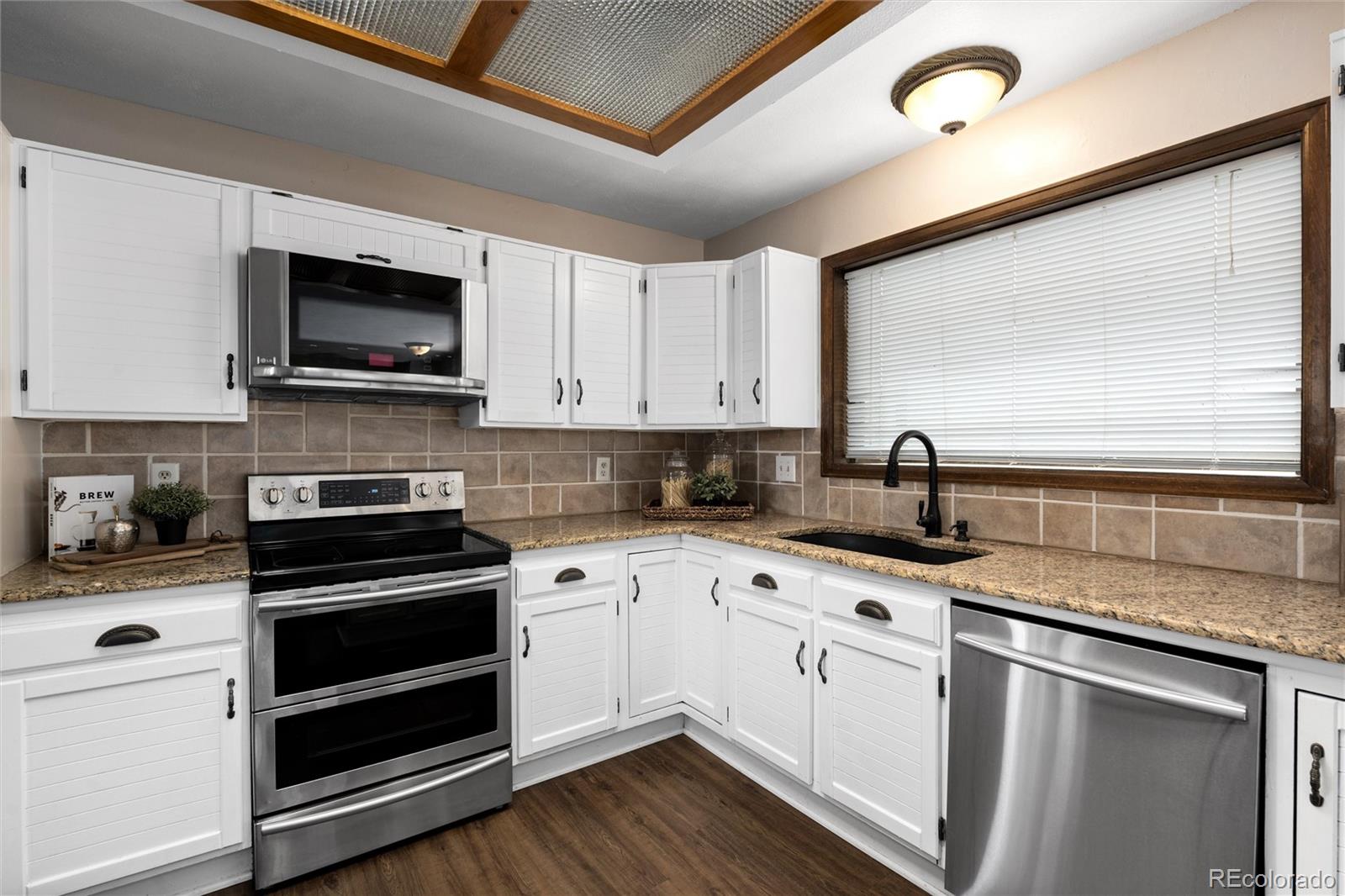 1225 East Goldsmith Drive Highlands Ranch, CO 80126 - Photo 14 of 40 a kitchen with granite countertop a sink stainless steel appliances and cabinets