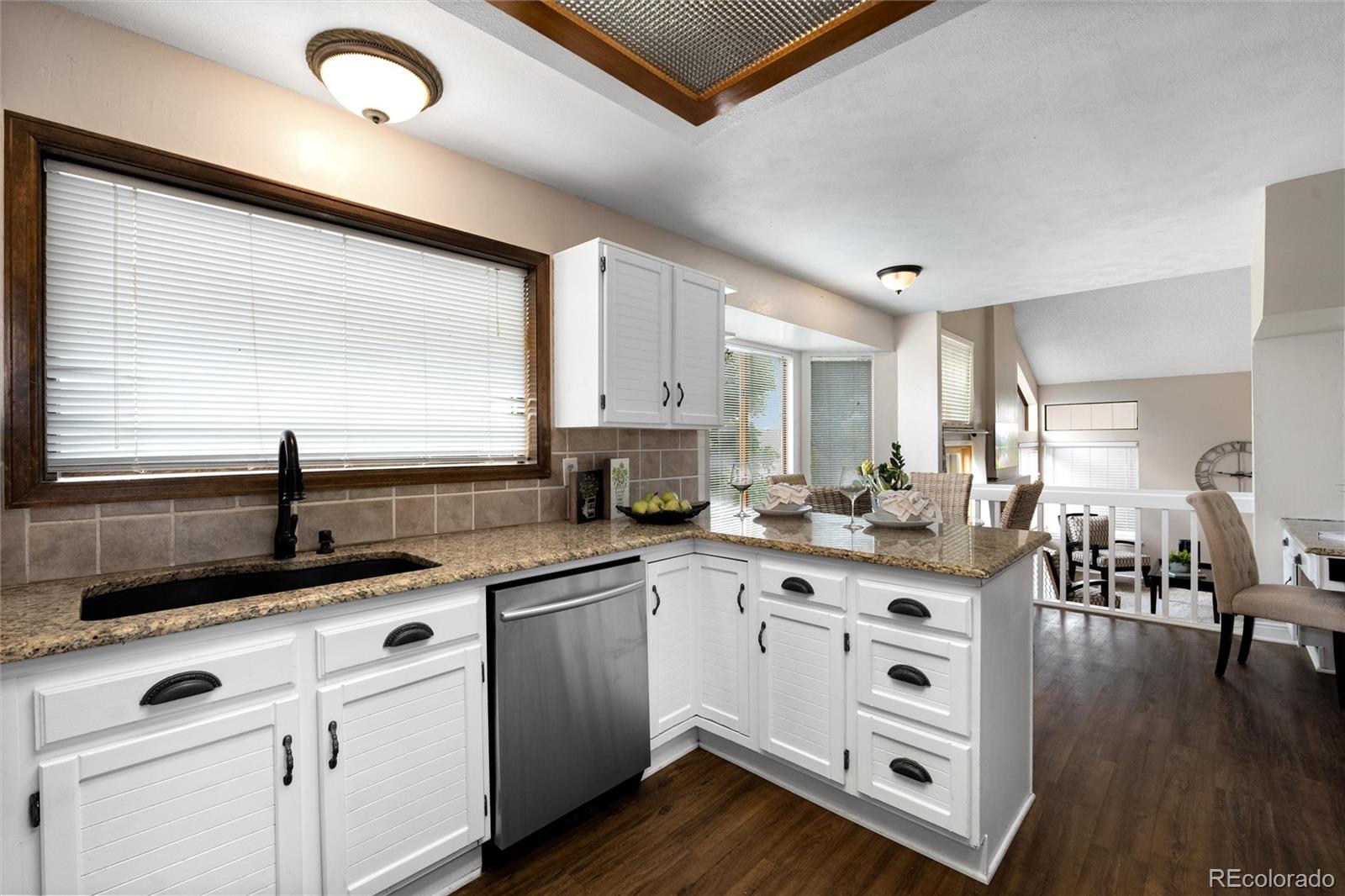 1225 East Goldsmith Drive Highlands Ranch, CO 80126 - Photo 15 of 40 a kitchen with sink cabinets and wooden floor