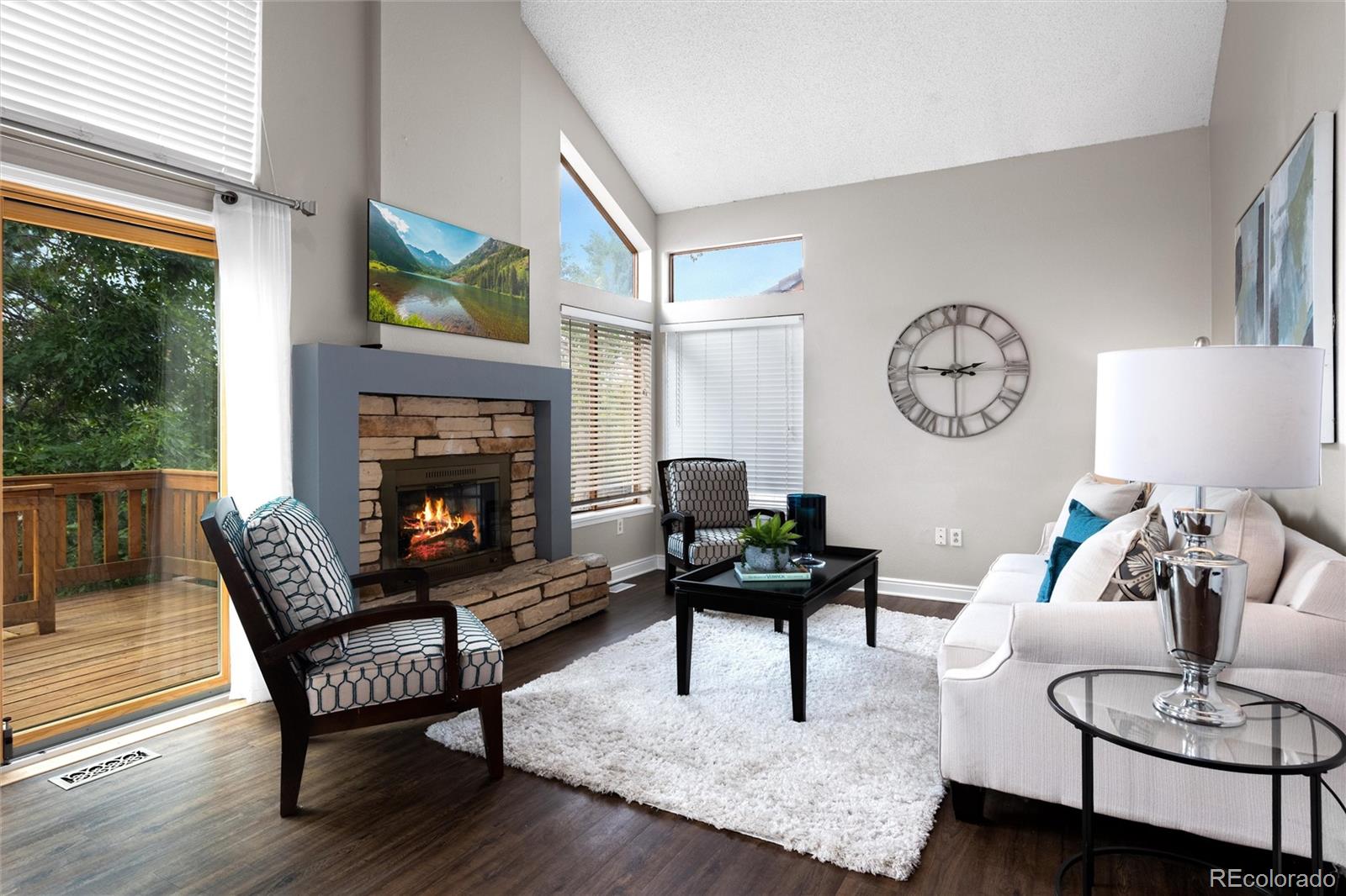 1225 East Goldsmith Drive Highlands Ranch, CO 80126 - Photo 17 of 40 a living room with furniture a clock and a fireplace