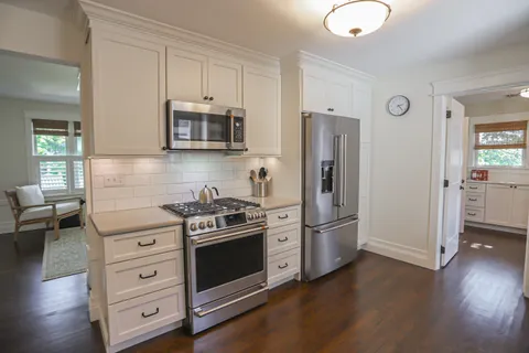 a kitchen with stainless steel appliances granite countertop a stove a refrigerator and a microwave