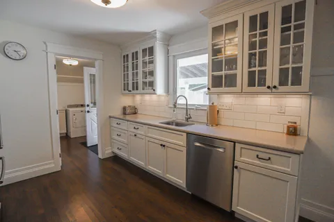 a kitchen with a sink cabinets and wooden floor