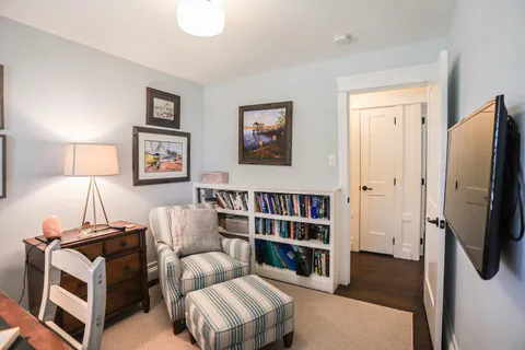 a living room with hard wood floors and a bed
