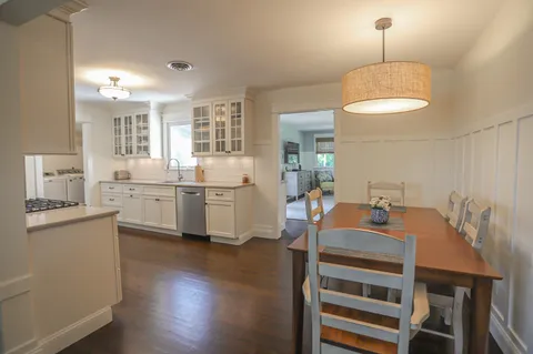 a open dining room with wooden floor and furniture