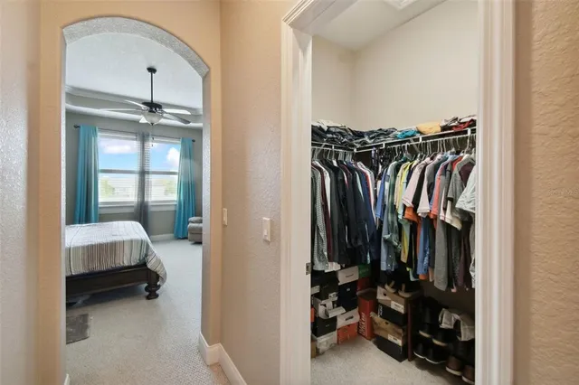 a view of walk in closet with clothes and shoes