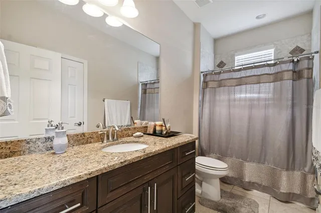 a bathroom with a granite countertop sink toilet and shower