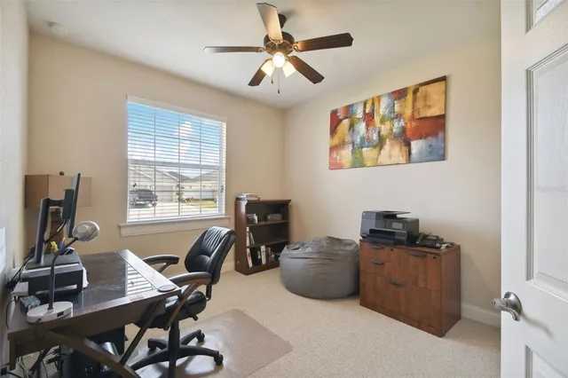 a view of a workspace with furniture and a window