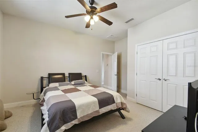 a bedroom with a bed and a ceiling fan