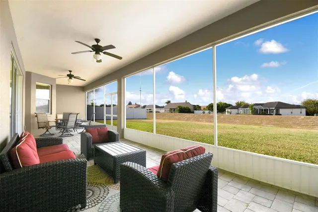 a living room with patio furniture and a floor to ceiling window