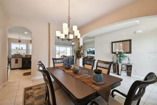 a view of a dining room with furniture a chandelier and wooden floor