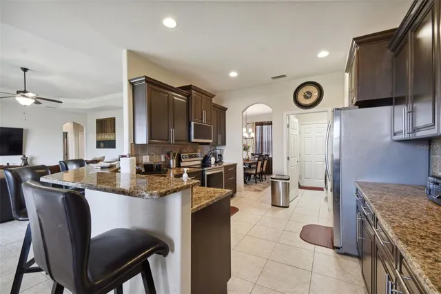 a kitchen with stainless steel appliances granite countertop a sink and a refrigerator