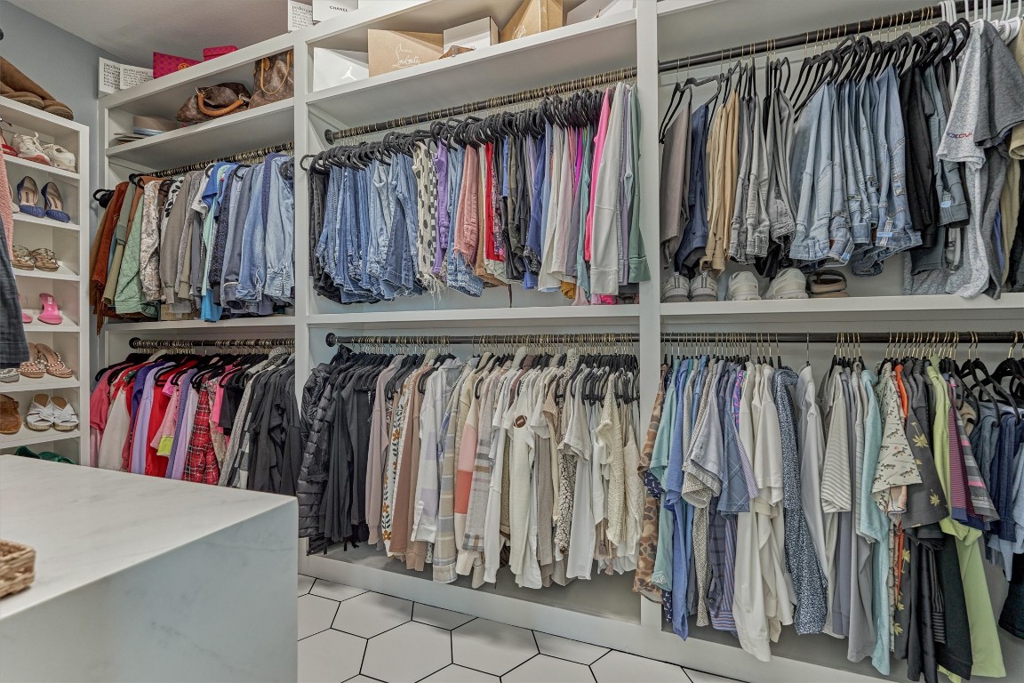 226 Hampton Glen Road Montgomery, TX 77356 - Photo 24 of 48 Recently updated walk-in closet with ample shelving and hanging space for clothes and shoes, featuring a clean, modern design with hexagonal tile flooring.