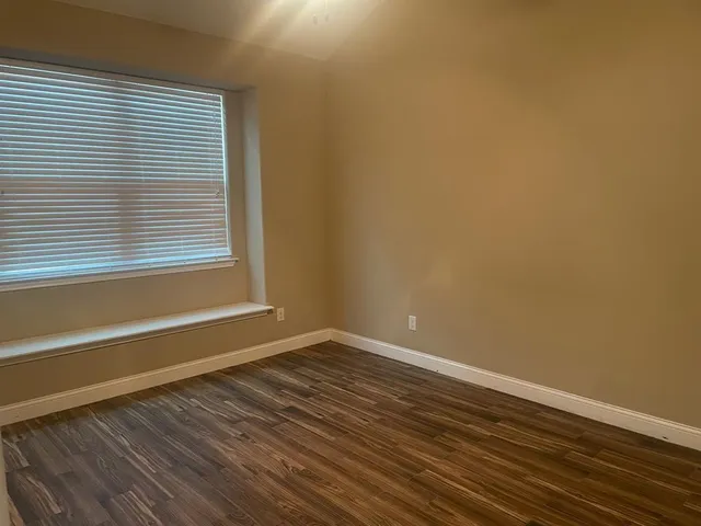 a view of a room with wooden floor and a window