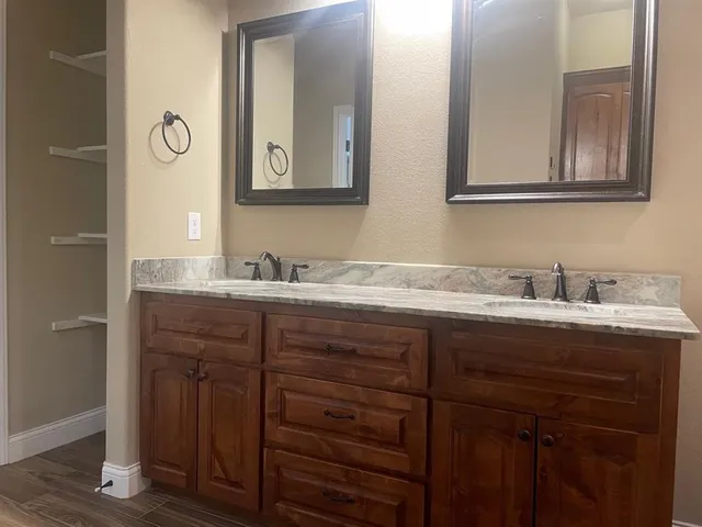 a bathroom with a granite countertop sink and a mirror