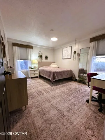 a spacious bedroom with a bed and wooden cabinets