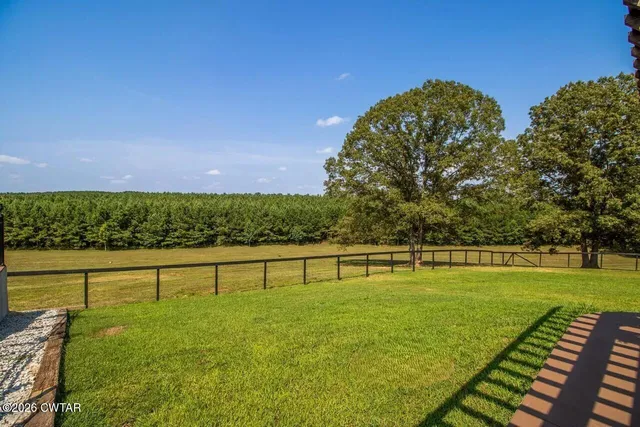 a view of a green field with wooden fence