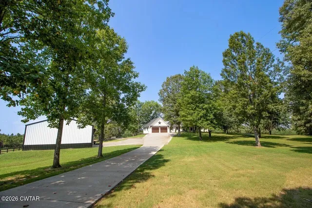 a view of yard with green space and trees