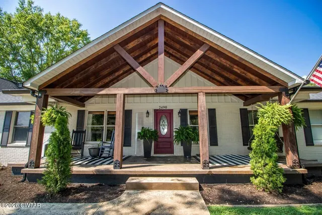 a view of a house with porch and potted plants