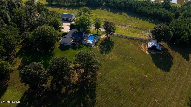 an aerial view of lake residential house with outdoor space and trees all around