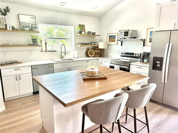 a kitchen with a dining table chairs and refrigerator