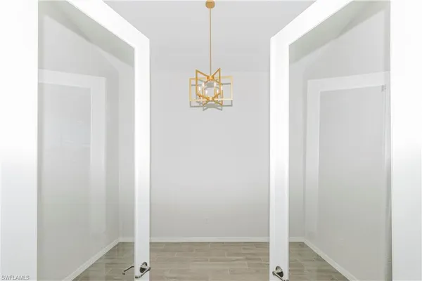a living room with furniture kitchen view and a chandelier