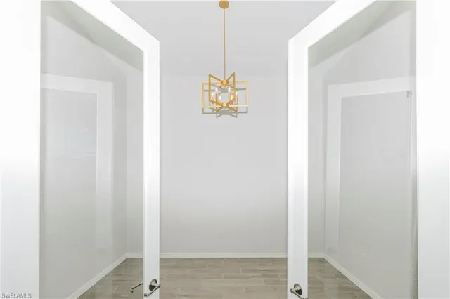 a living room with furniture kitchen view and a chandelier