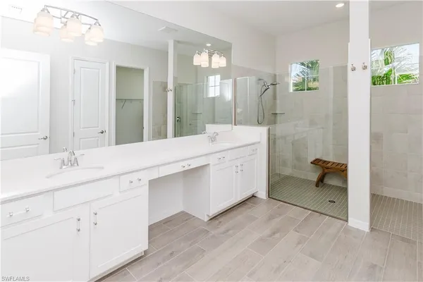 a bathroom with a double vanity sink a mirror and a bathtub