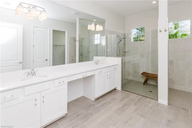 a bathroom with a double vanity sink a mirror and a bathtub