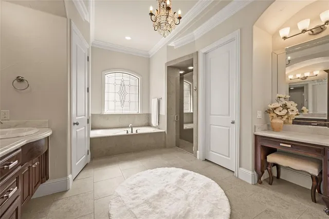 a bedroom with a bed next to a window and a chandelier