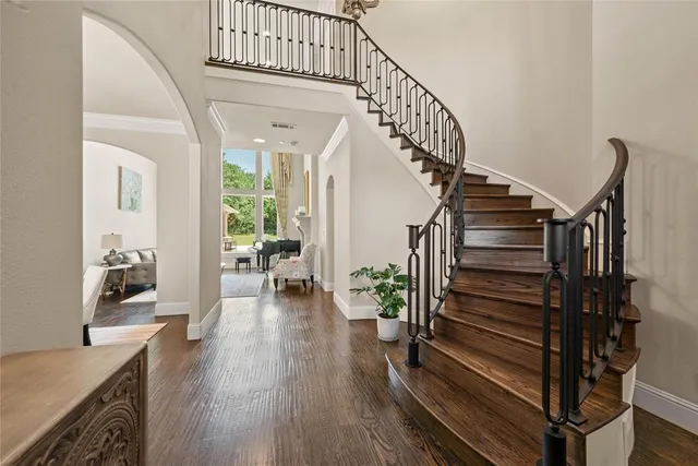 a large kitchen with granite countertop a stove oven a sink dishwasher a dining table and chairs with wooden floor