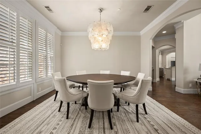 a dining room with furniture a chandelier and wooden floor
