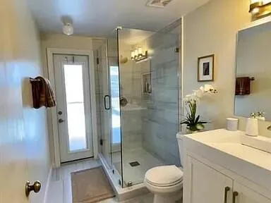 a bathroom with a sink a toilet and shower