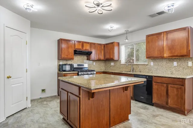 a kitchen with stainless steel appliances granite countertop a sink stove and cabinets