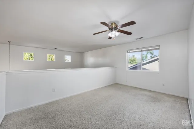 an empty room with chandelier fan